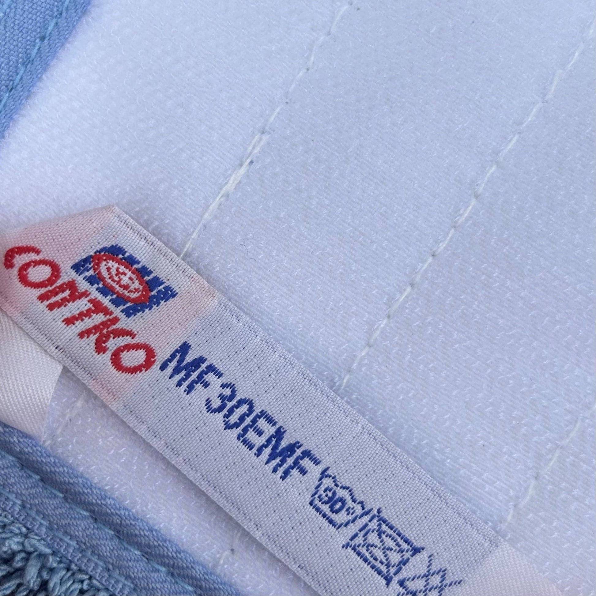 A close up photo of the label on the contico blue flat mop head.